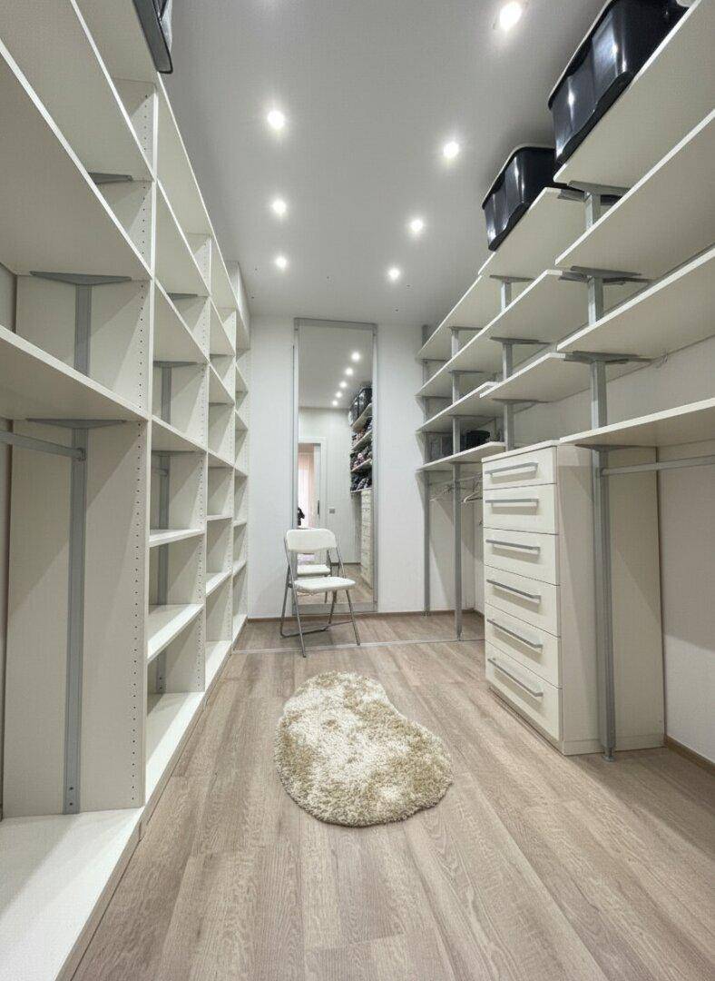 Geräumiger begehbarer Kleiderschrank mit offenen Regalsystemen und viel Stauraum.