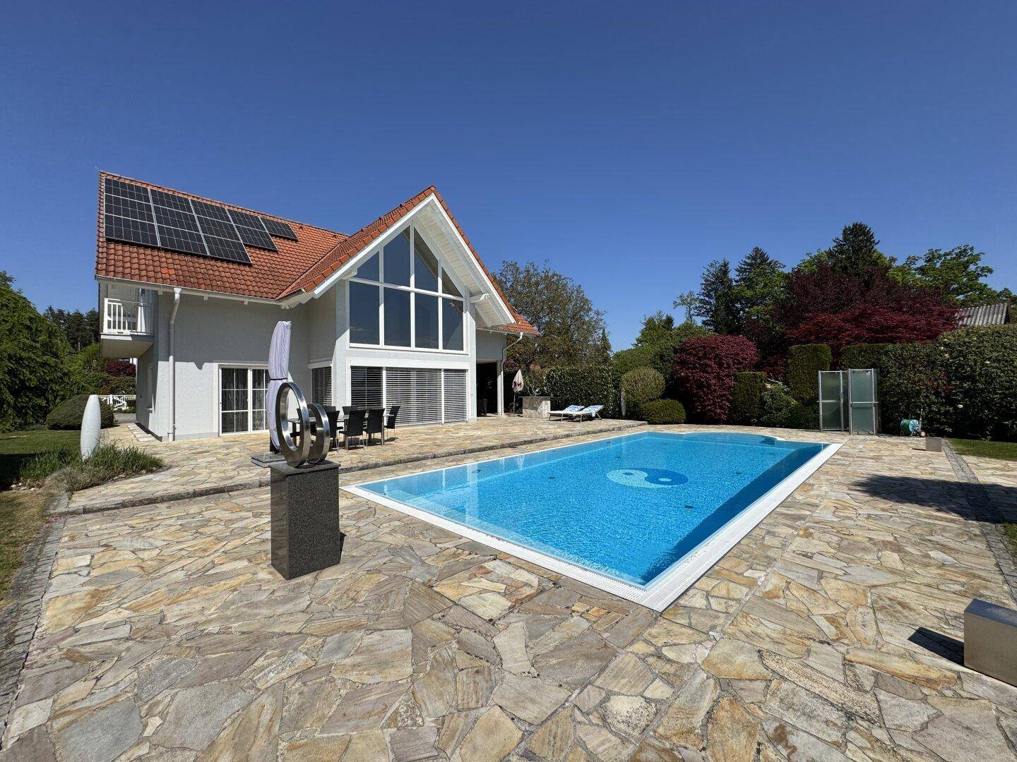 Gesamtaufnahme des Hauses mit Pool, Sonnenterrasse und Photovoltaikanlage auf dem Dach.