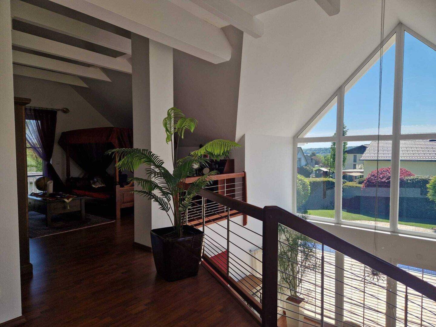 Helle Galerie im Obergeschoss mit Holzboden und weitem Blick durch die Giebelfenster.