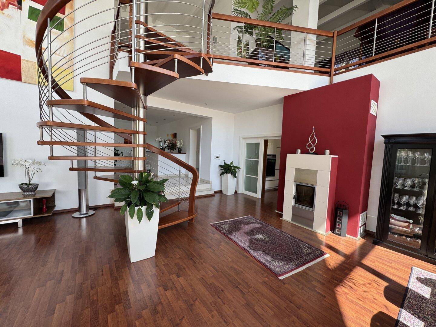 Geräumiger Wohnbereich mit Kamin, eleganter Wendeltreppe und Zugang zur Galerie.