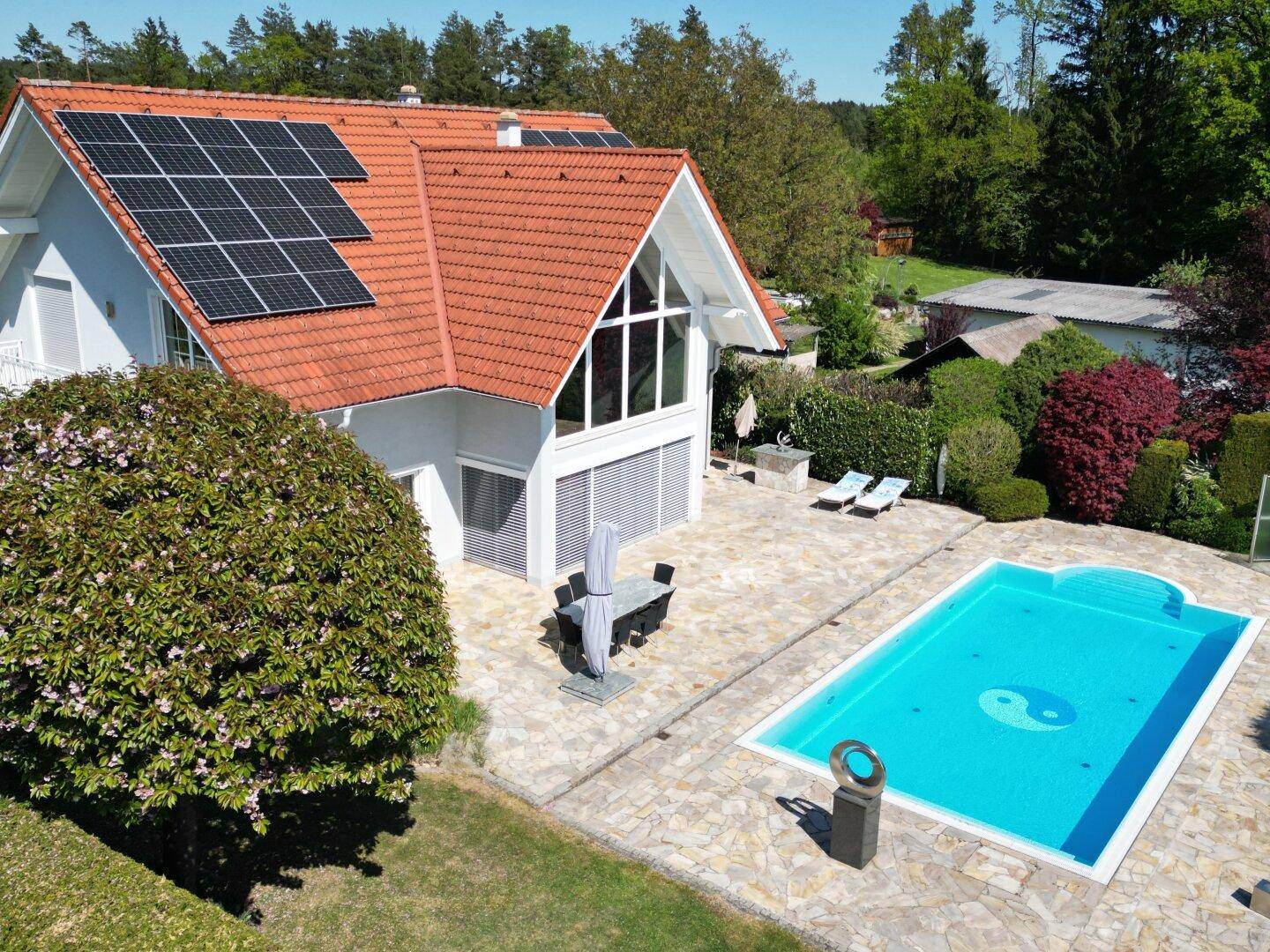 Luftaufnahme des Hauses mit Pool, Sonnenterrasse und Photovoltaikanlage auf dem Dach.