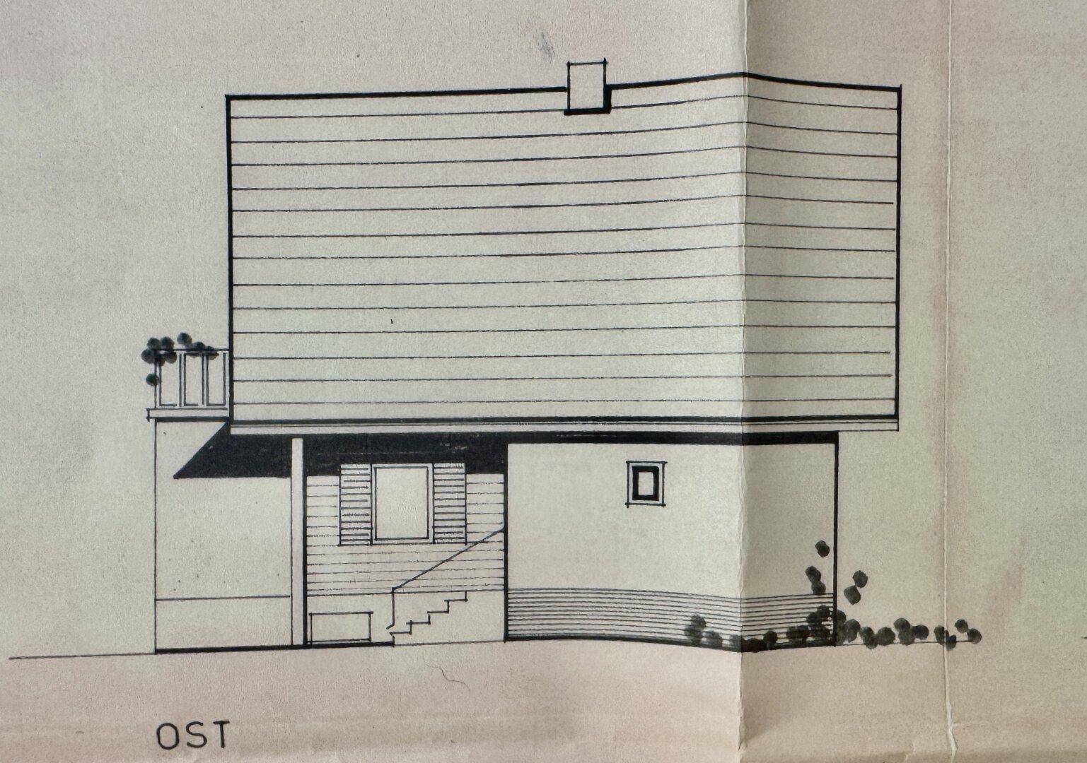 Ostansicht des Gebäudes mit einem kleinen Balkon und einer Treppe zum Eingangsbereich.