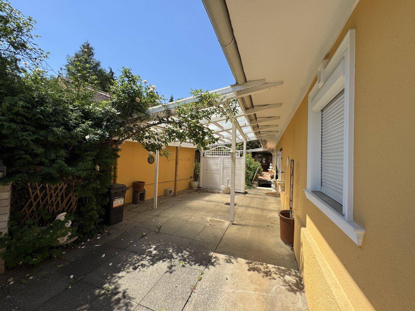 Überdachte Terrasse mit Steinplattenboden, ideal für entspannte Stunden im Freien.