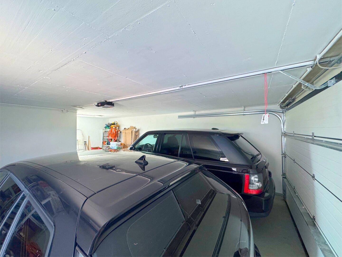 Geräumige Garage mit Platz für zwei Fahrzeuge und Stauraum.