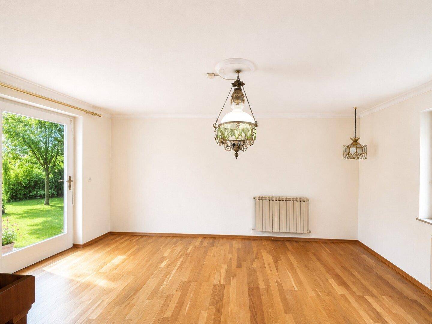 Geräumiges Zimmer mit Holzboden, Stuckdecke und direktem Zugang zum Garten.