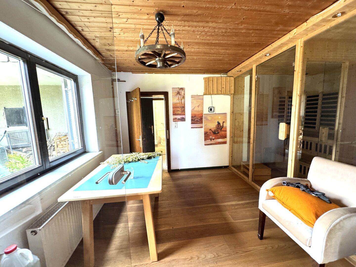 Wellnessbereich mit Sauna, Holzbalkendecke und Sitzgelegenheiten, hell und einladend.