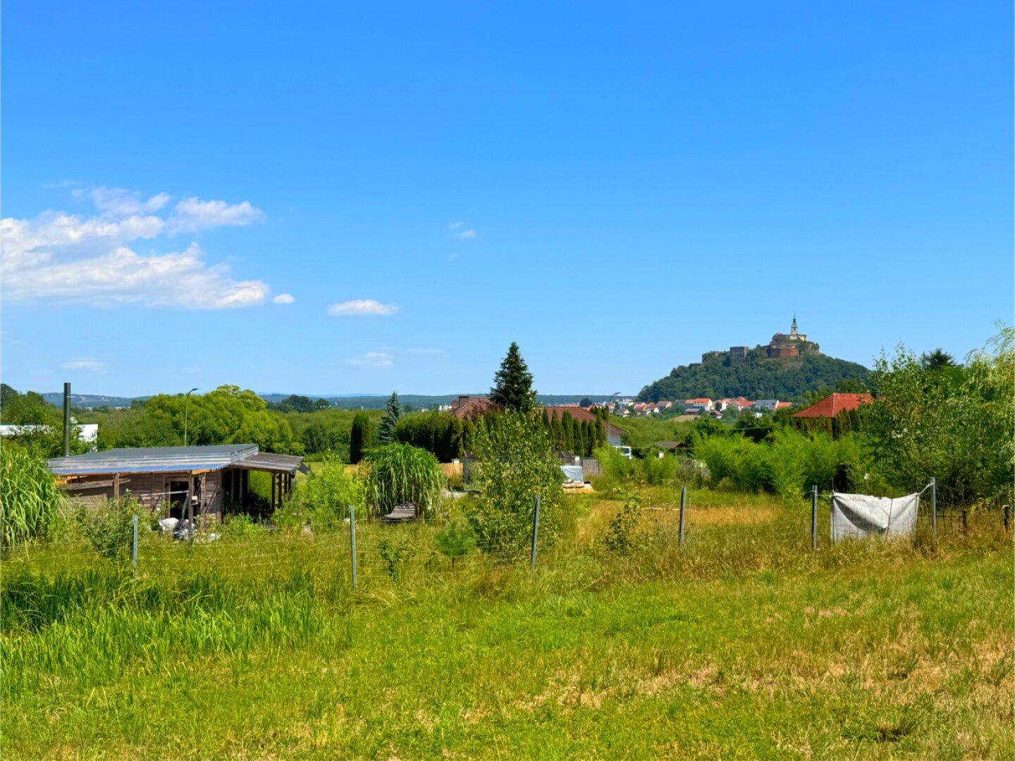Panoramablick über die grüne Landschaft mit dem Anwesen und einem historischen Schloss in der Ferne.