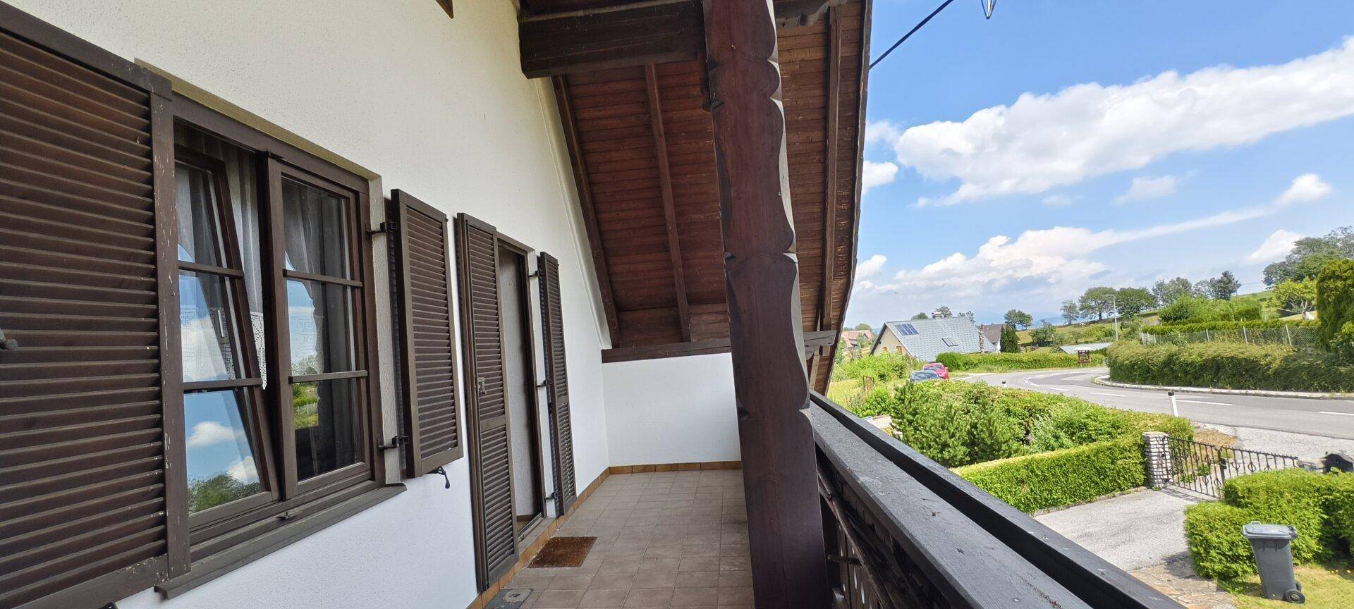 Geräumiger Balkon mit traditionellen Holzfensterläden und weitem Blick auf die ländliche Umgebung.
