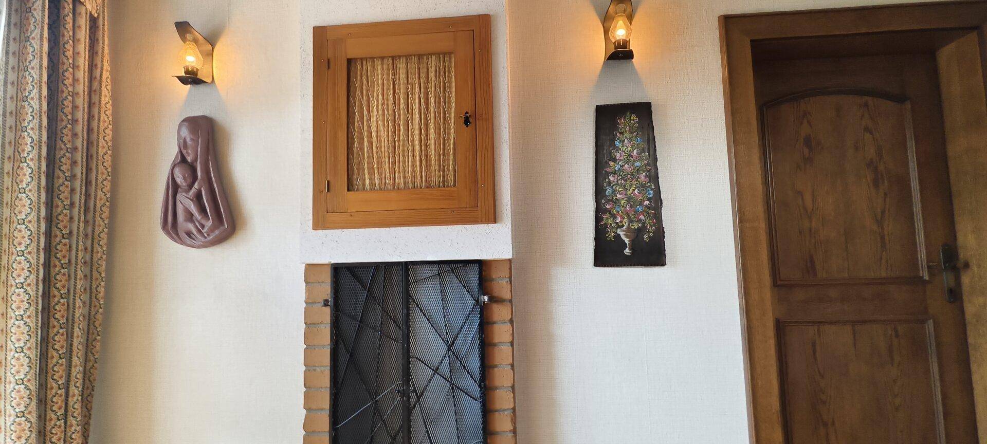 Wanddekorationen mit Wandleuchten und einer Holztür in einem traditionellen Interieur.
