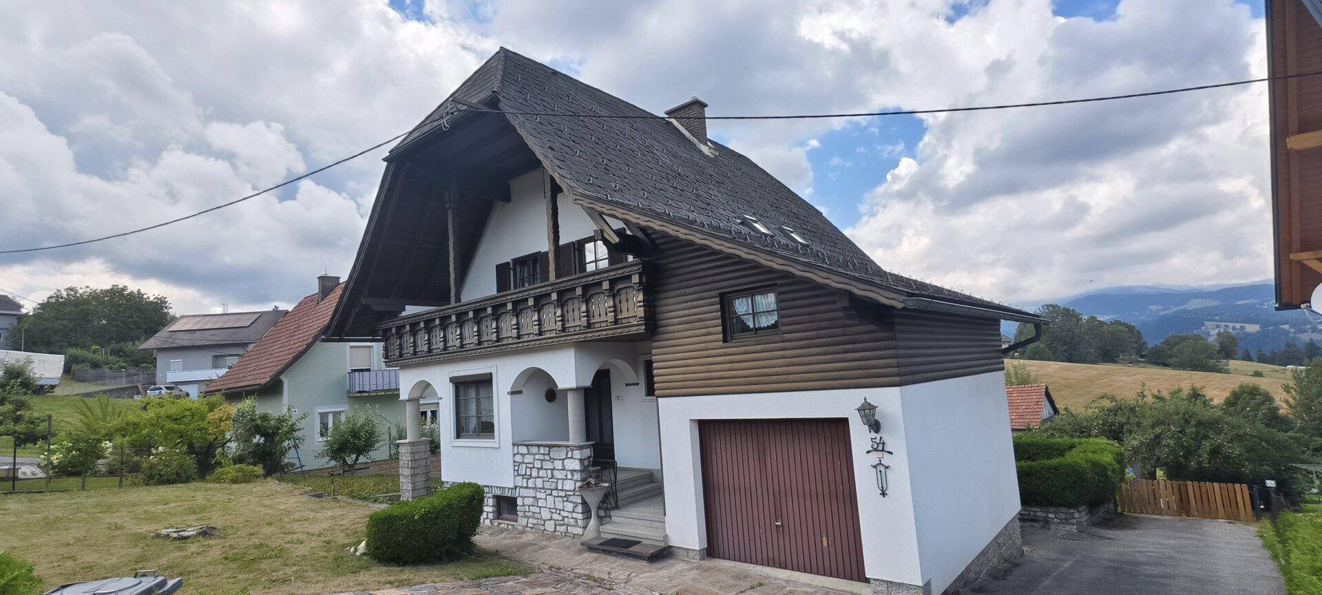 Traditionelles Haus mit Satteldach, Balkon und integrierter Garage.