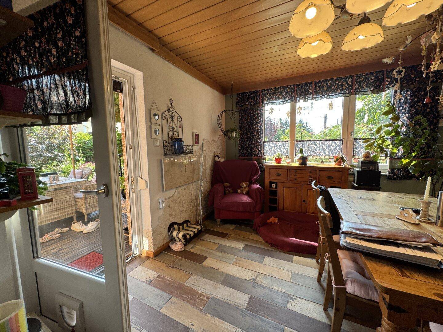 Essbereich mit Zugang zur Terrasse, Holzboden und traditioneller Einrichtung.