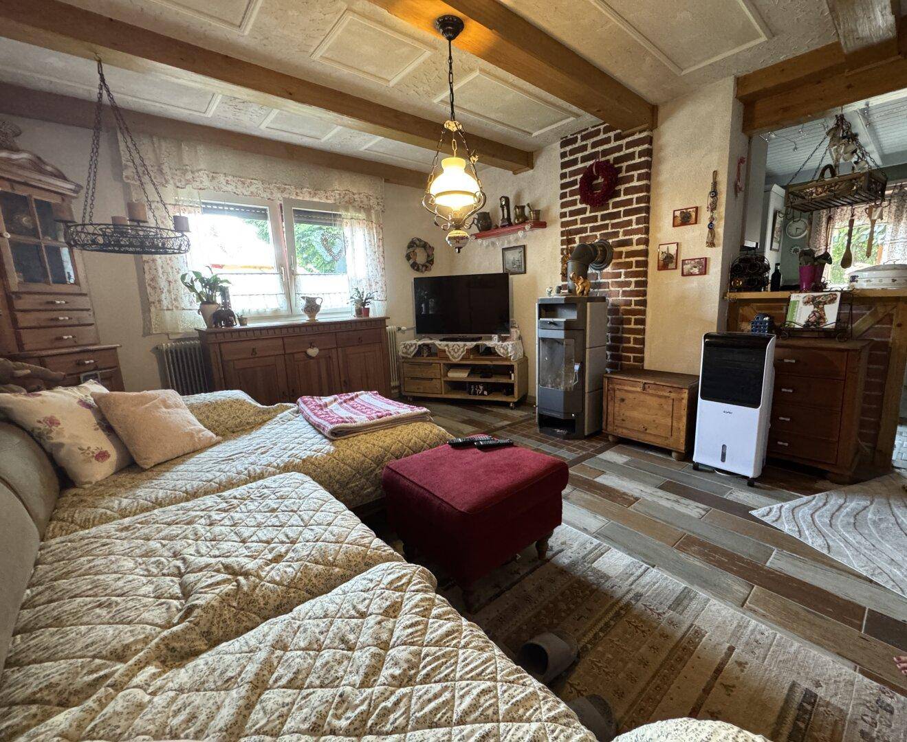 Wohnzimmer mit bequemer Couch, Kaminofen und traditioneller Einrichtung.