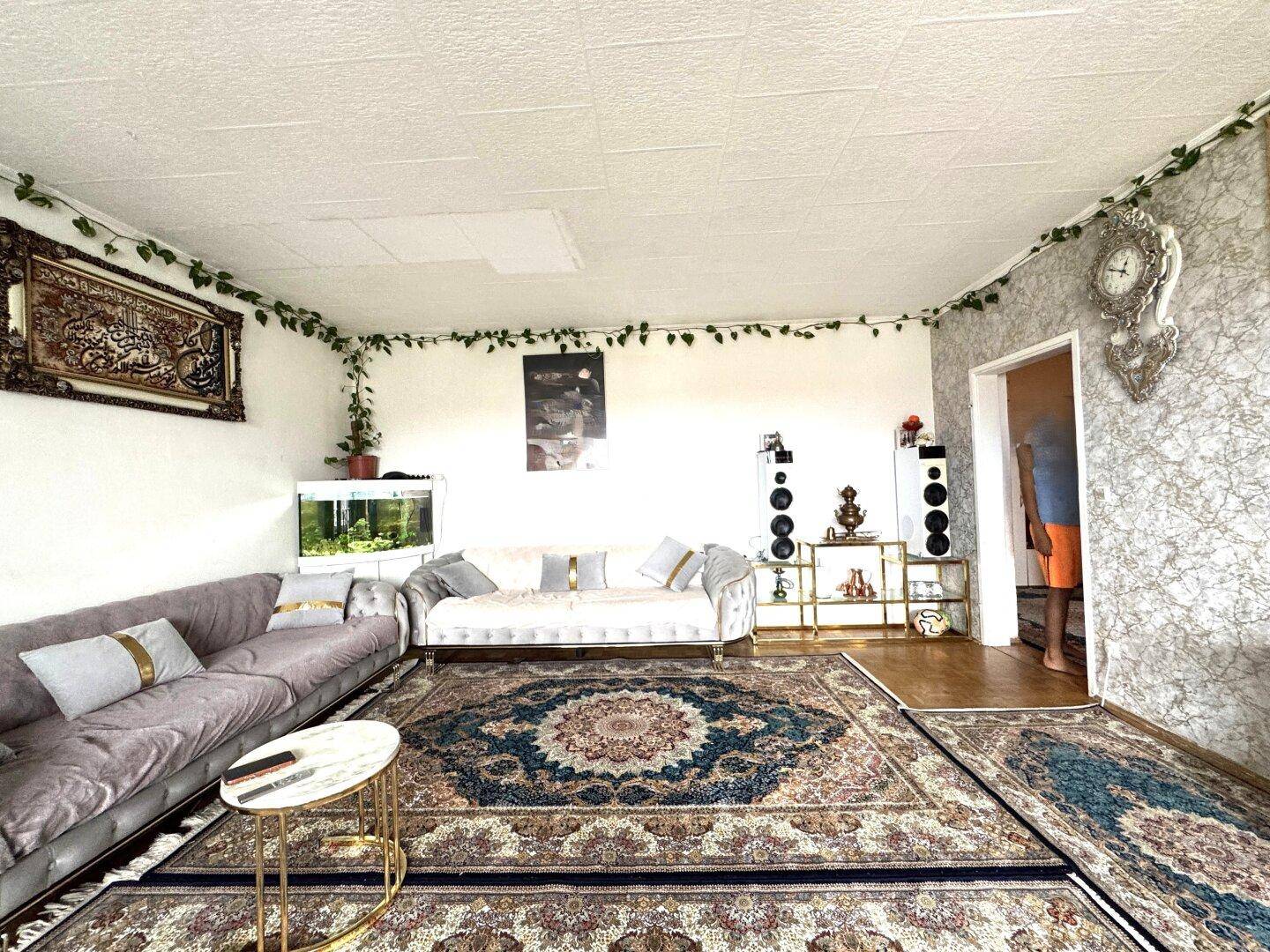 Wohnzimmer mit bequemen Sofas, orientalischen Teppichen und dekorativen Wandelementen.