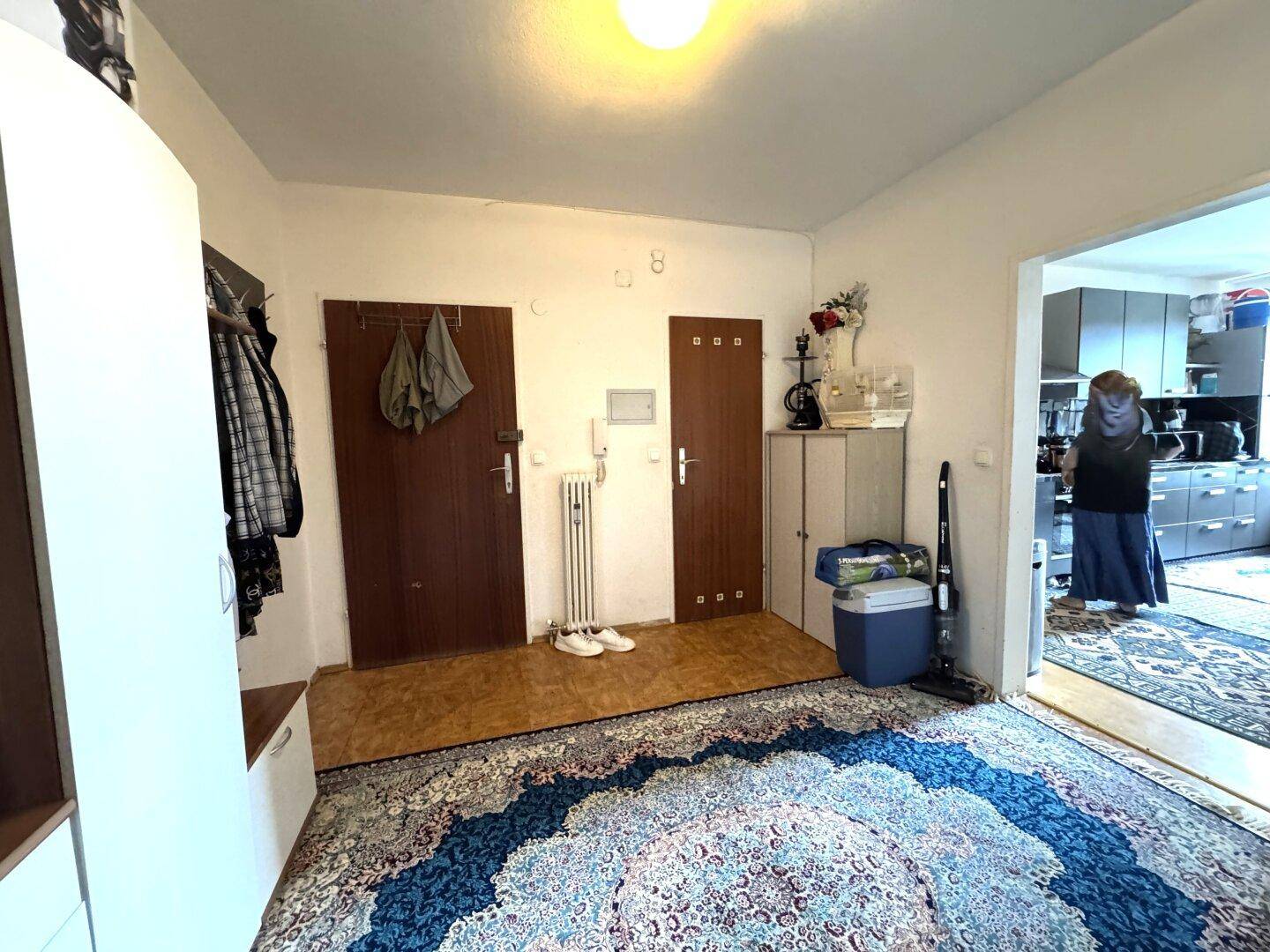 Eingangsbereich mit Garderobe und Blick in die angrenzende Küche.