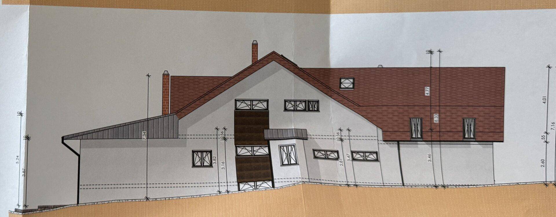 Seitenansicht des Gebäudes mit Satteldach und verschiedenen Fensterformen, zeigt moderne Architektur.