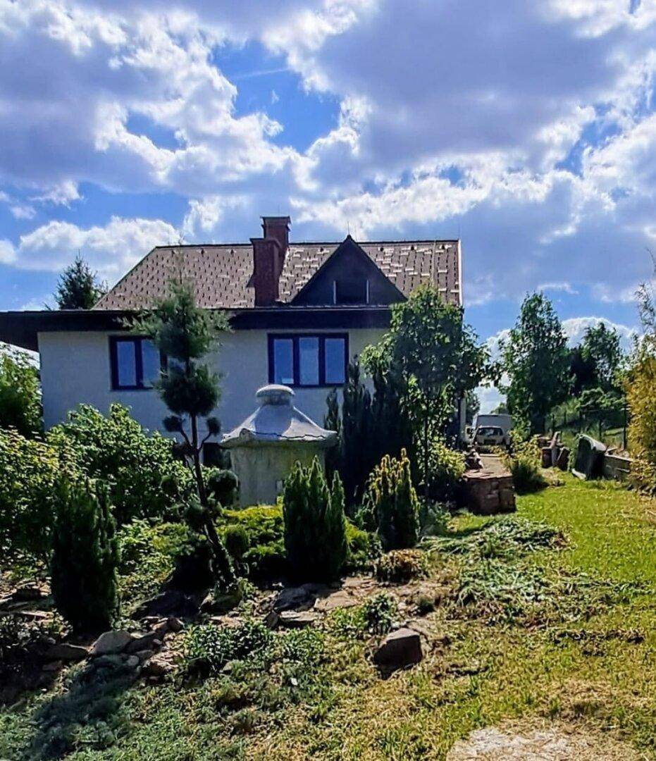 Weitläufiger Gartenbereich mit altem Baumbestand und Blick auf das Wohnhaus.