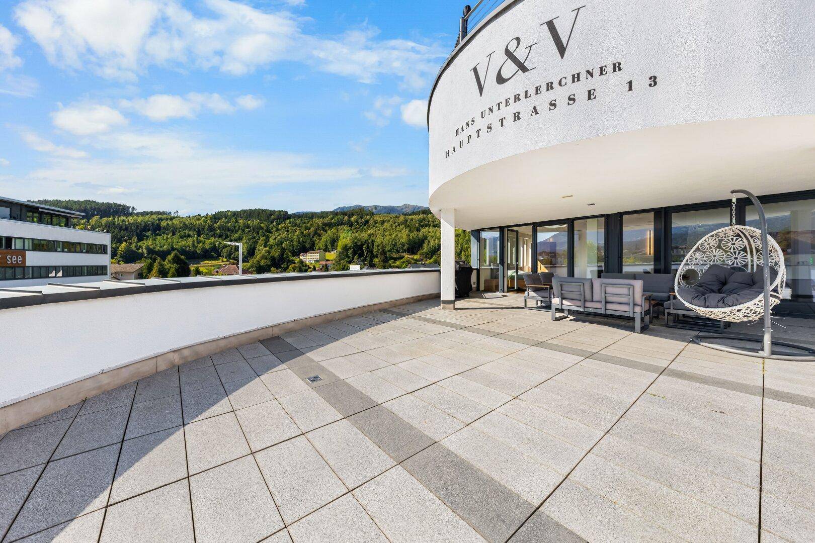 Weitläufige Außenterrasse mit moderner Architektur und Panoramablick auf die umliegende Landschaft.