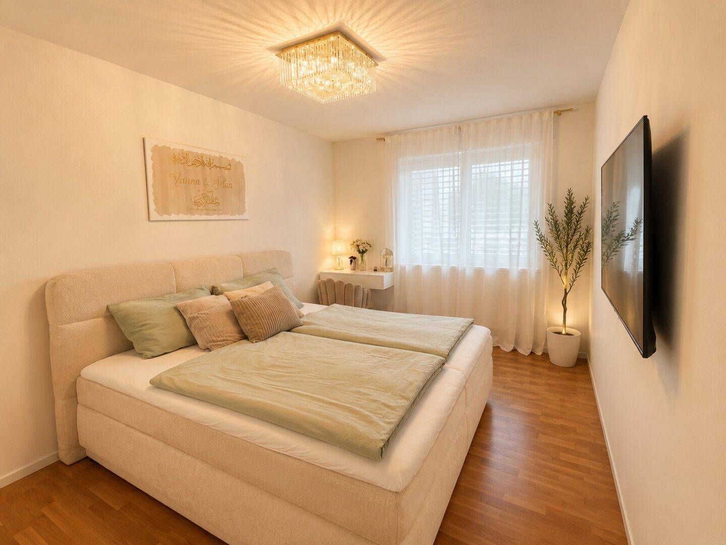 Gemütliches Schlafzimmer mit Doppelbett, Parkettboden und großem Fenster.