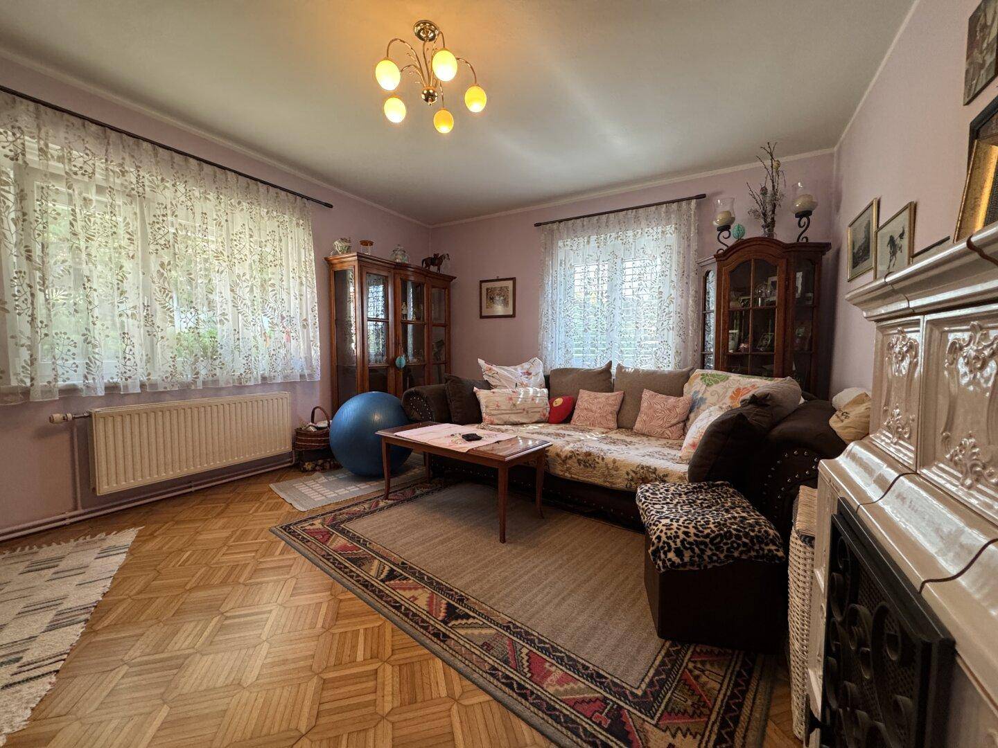 Gemütliches Wohnzimmer mit Parkettboden, Kamin und traditionellen Holzmöbeln.