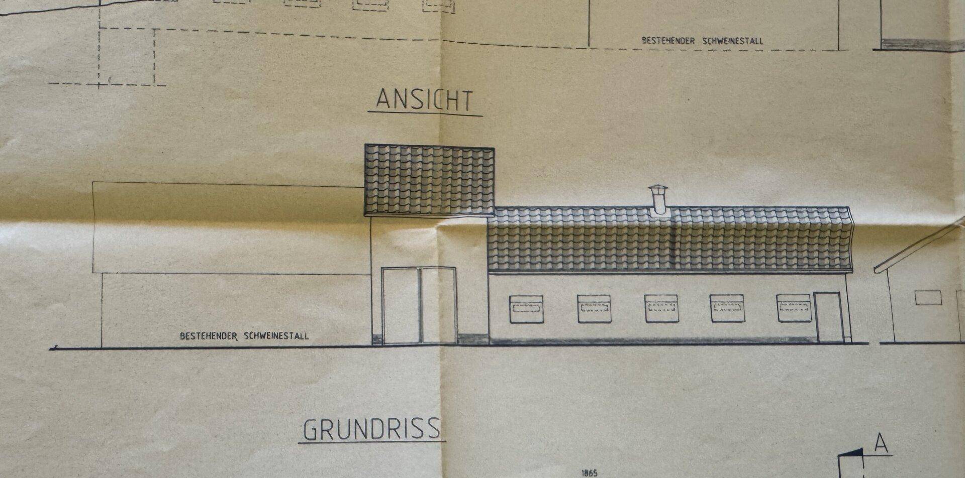 Vorderansicht eines Gebäudes mit mehreren Fenstern und Türen, zeigt die Fassadengestaltung.