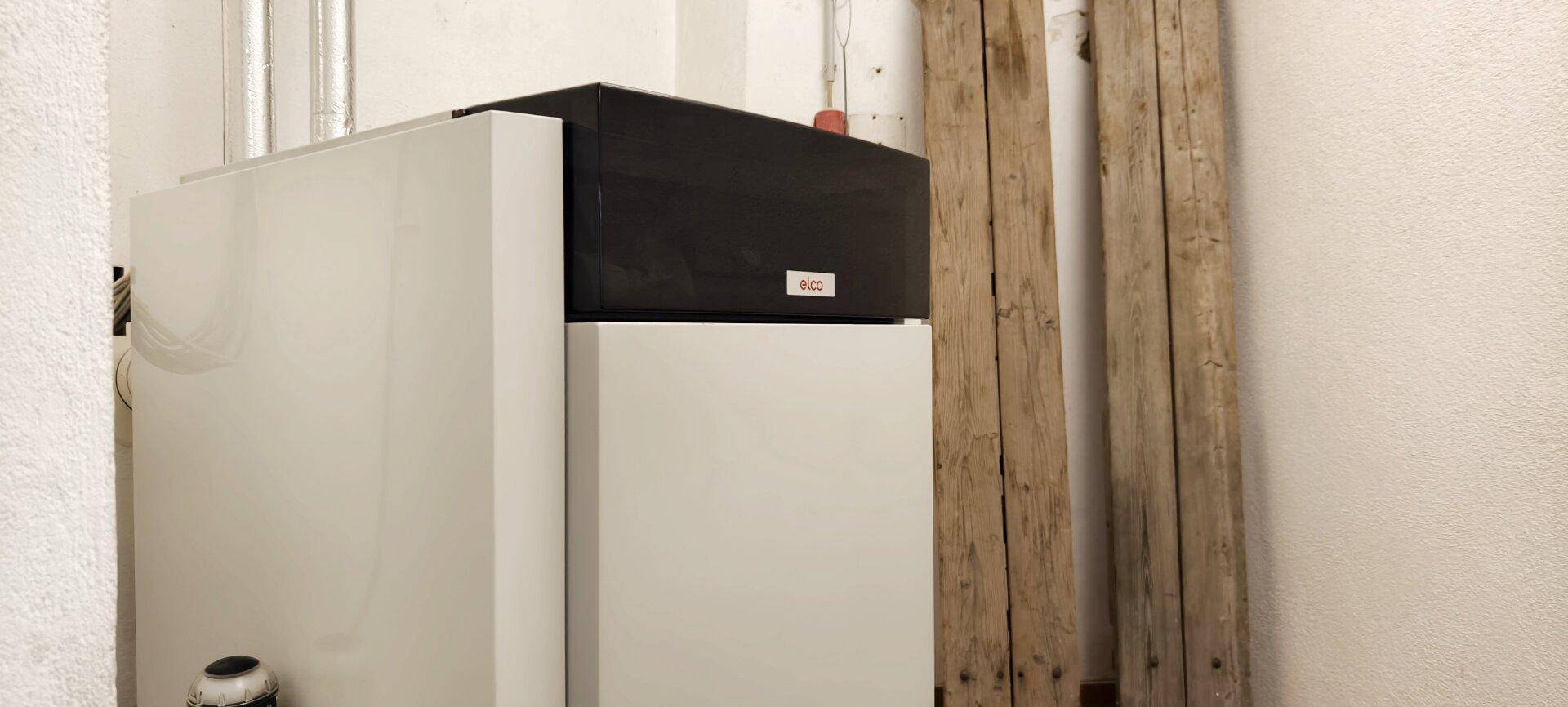 Technikraum mit moderner Heizungsanlage und Lagerfläche für Holzbretter.