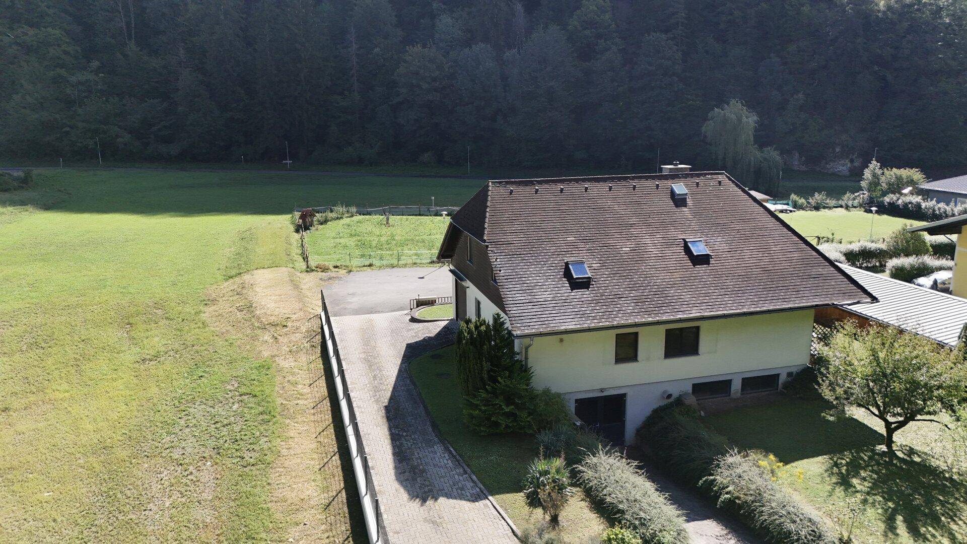 Einfamilienhaus mit gepflegter Auffahrt, Gartenbereich und weitem Blick auf die umliegende Landschaft.