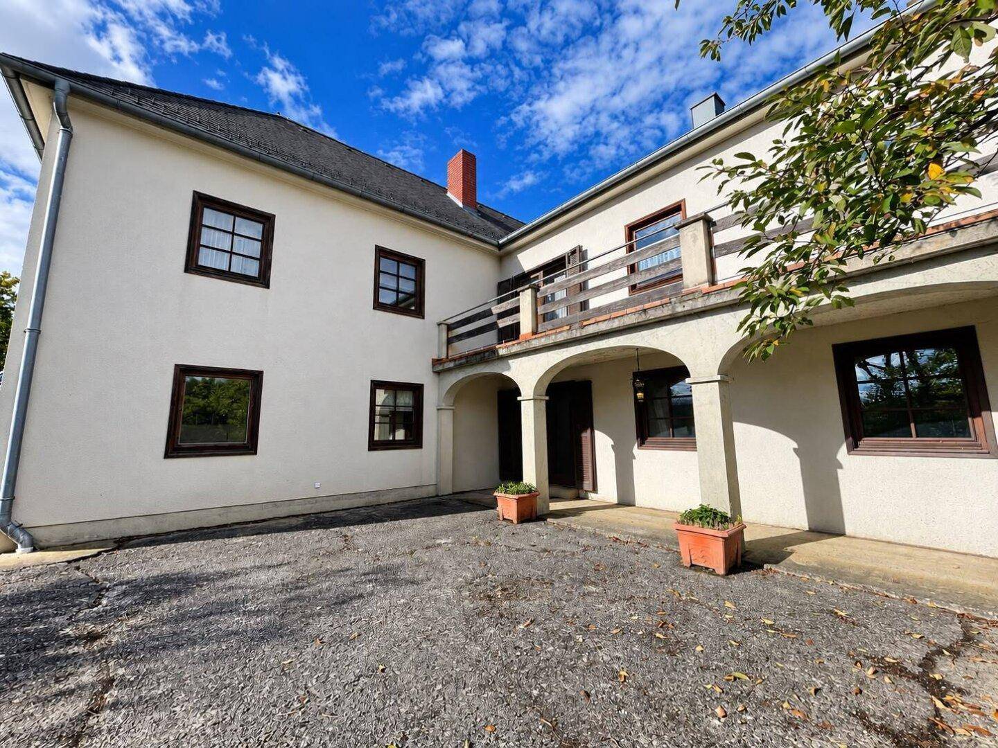 Gepflasterter Hofbereich an der Rückseite des Hauses mit Zugang zu den Arkaden.