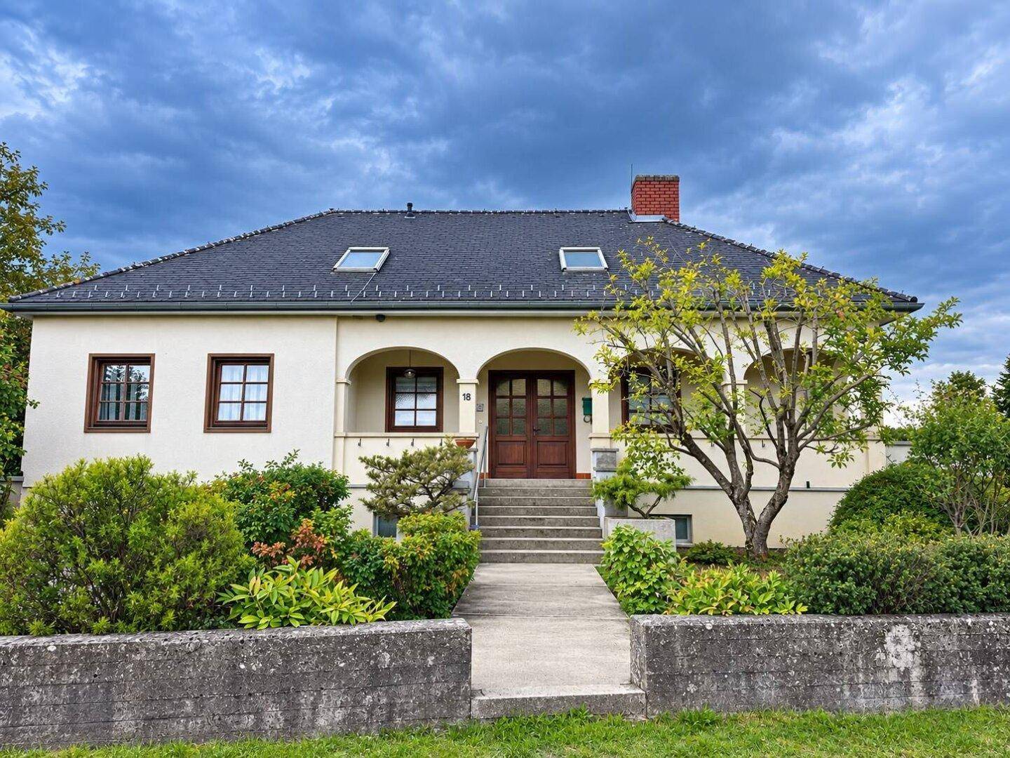 Eingangsansicht des Hauses mit gepflegtem Vorgarten und klassischer Architektur.
