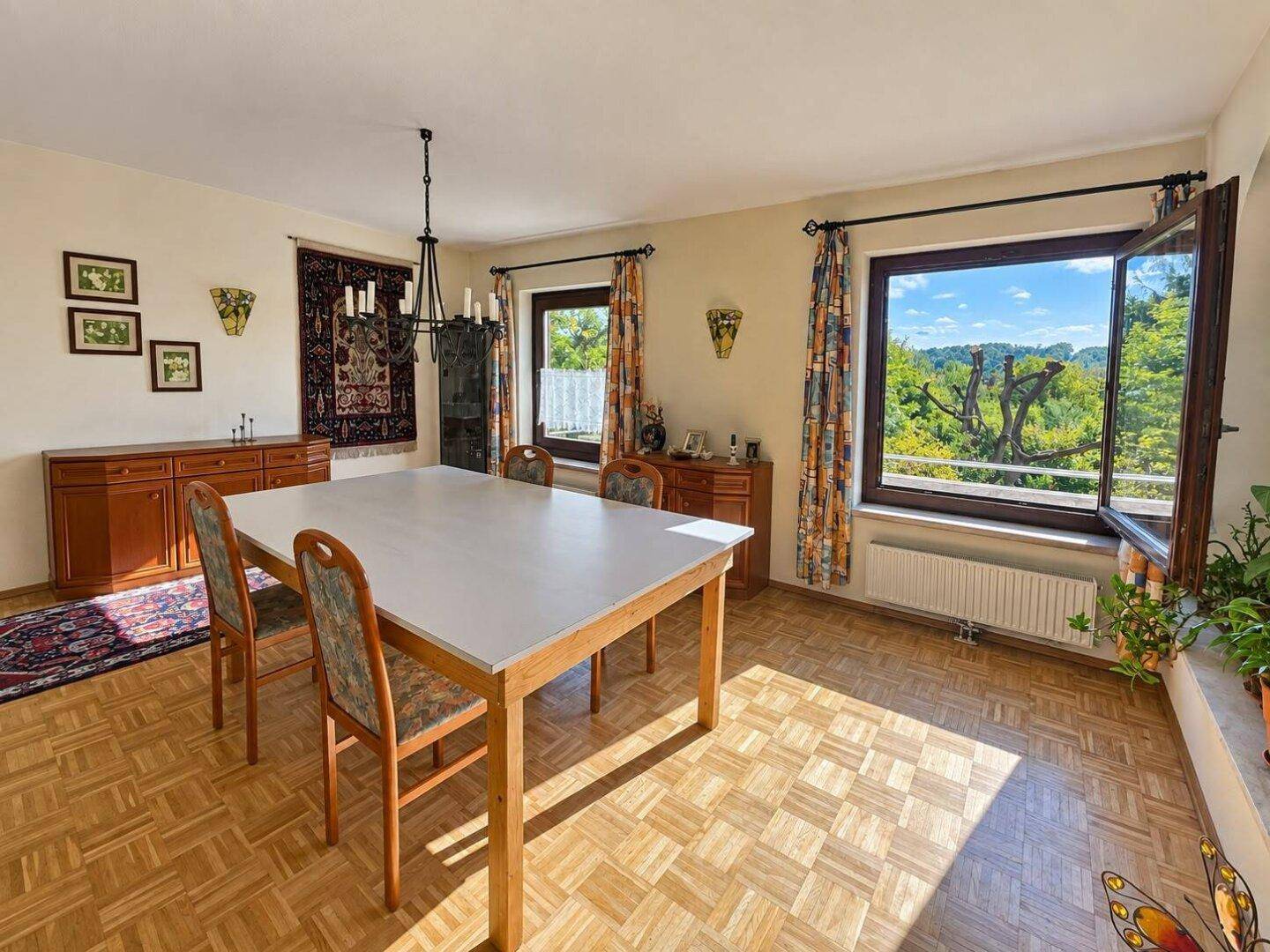 Großzügiges Esszimmer mit Parkettboden, großem Esstisch und weitem Ausblick.