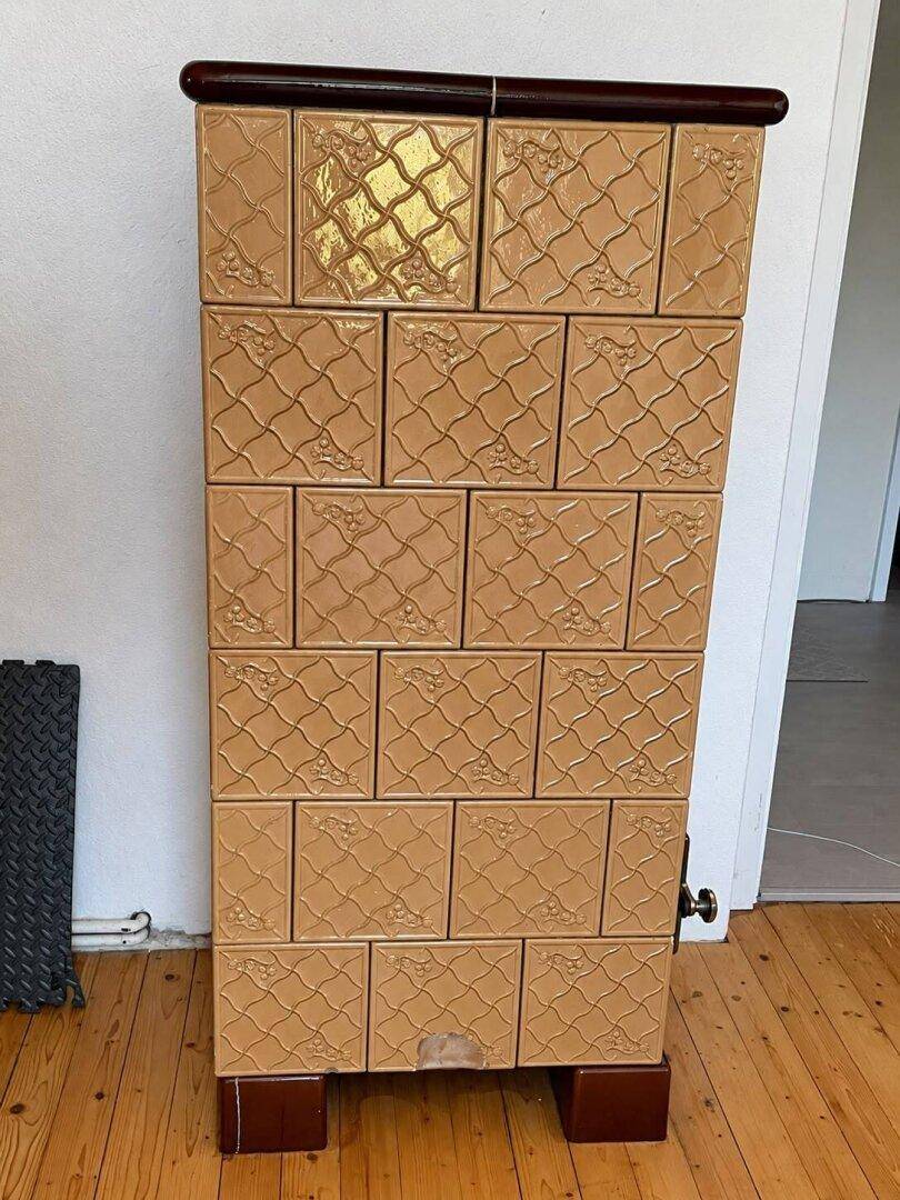 Traditioneller Kachelofen mit dekorativen Fliesen, der Wärme und Gemütlichkeit spendet.