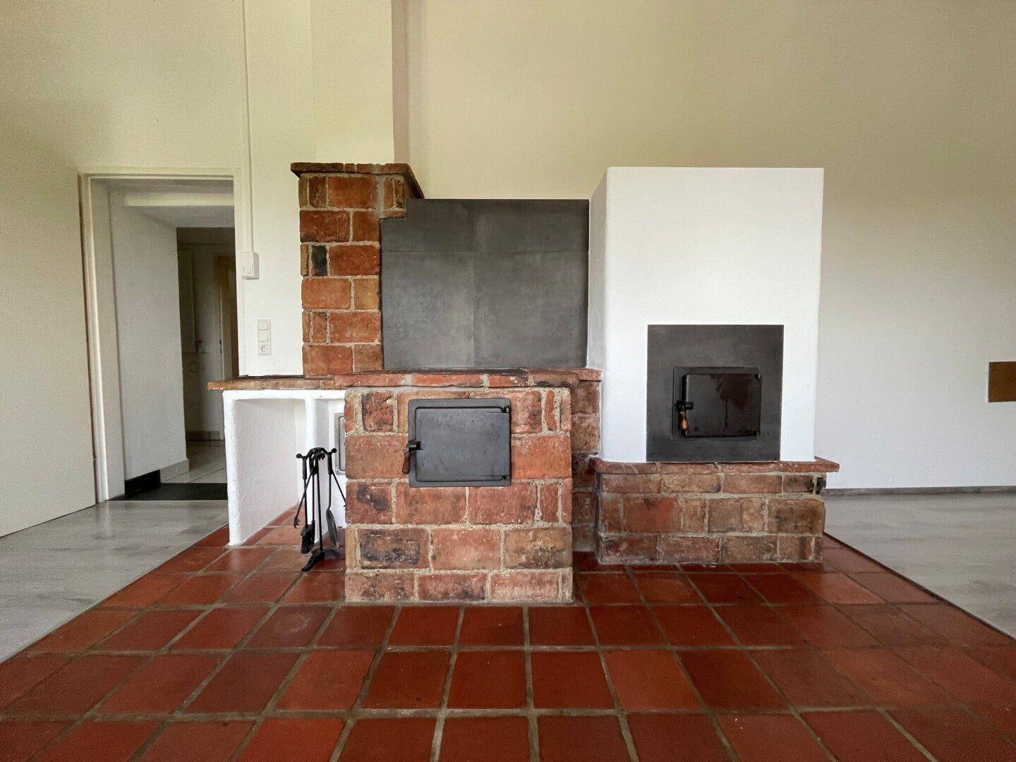 Detailansicht von zwei traditionellen Kaminen aus Ziegelstein mit Terrakotta-Fliesenboden im Wohnbereich.