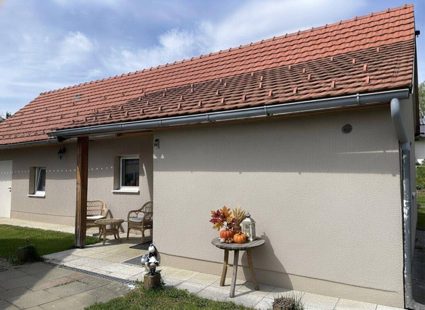 Nebengebäude mit verputzter Fassade und kleiner überdachter Veranda.