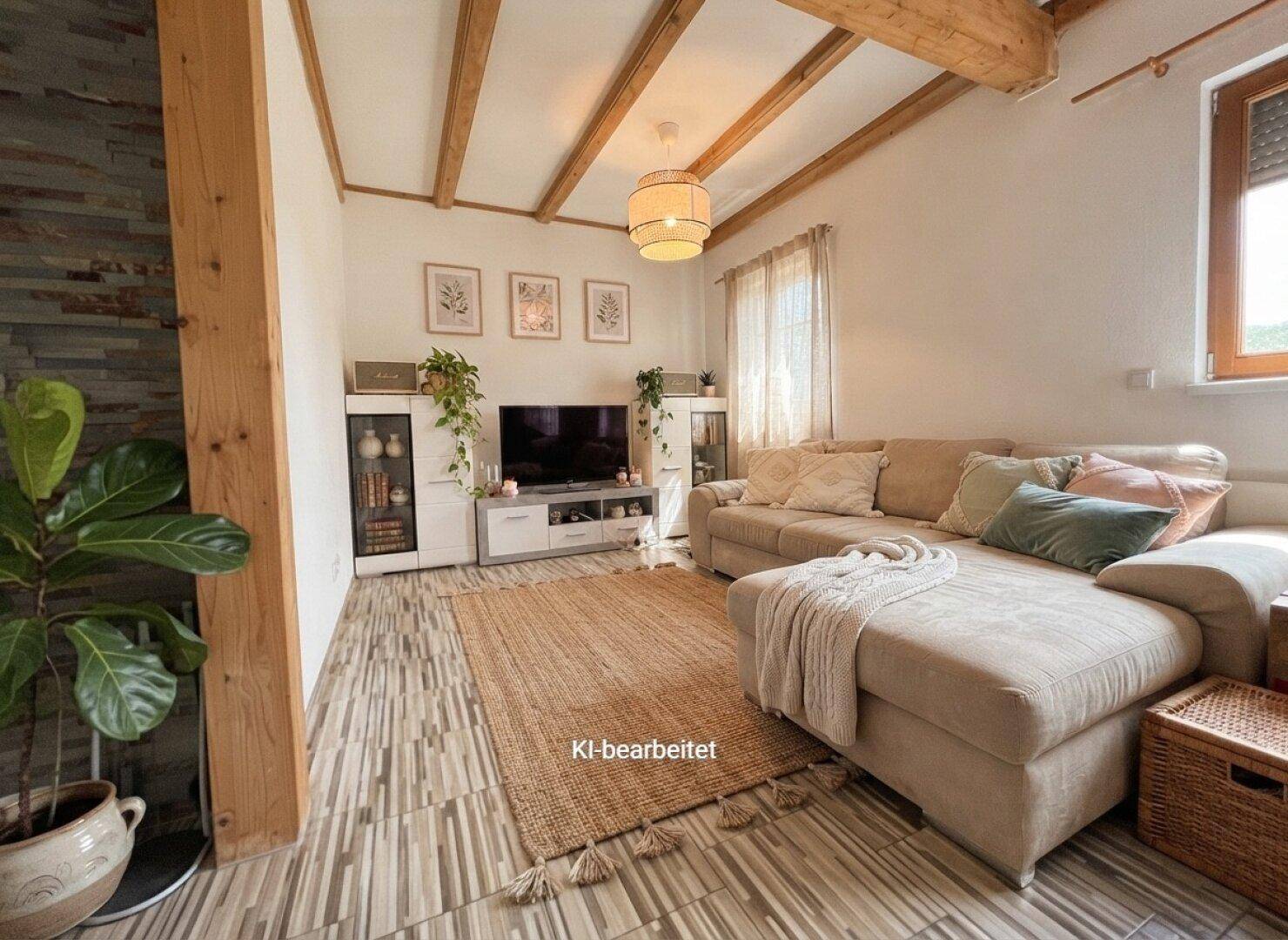 Helles Wohnzimmer mit beigem Sofa, Teppich und Holzbalkendecke.