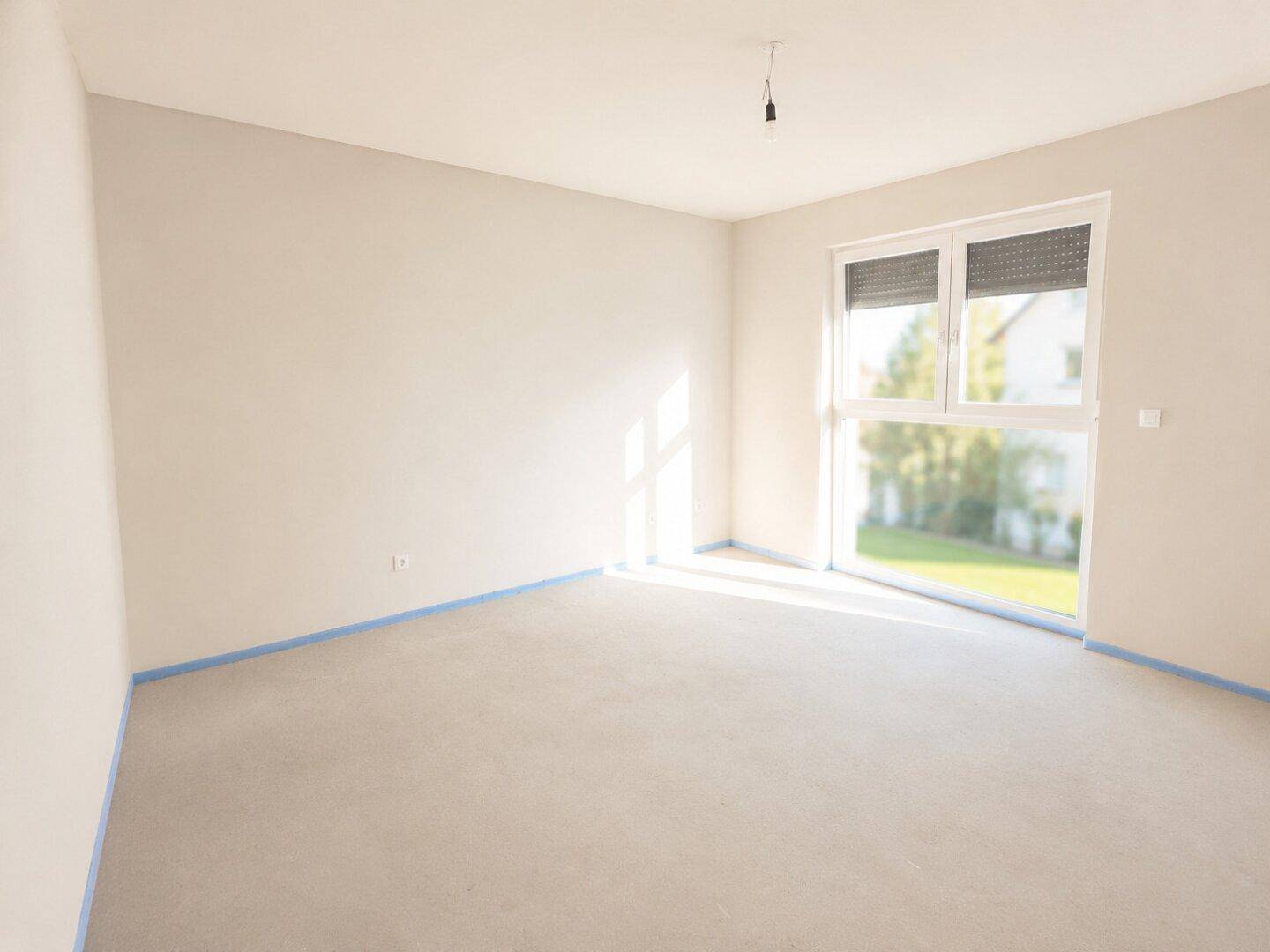 Unmöblierter Raum mit großen Fenstern, viel Tageslicht und Blick in die Umgebung.