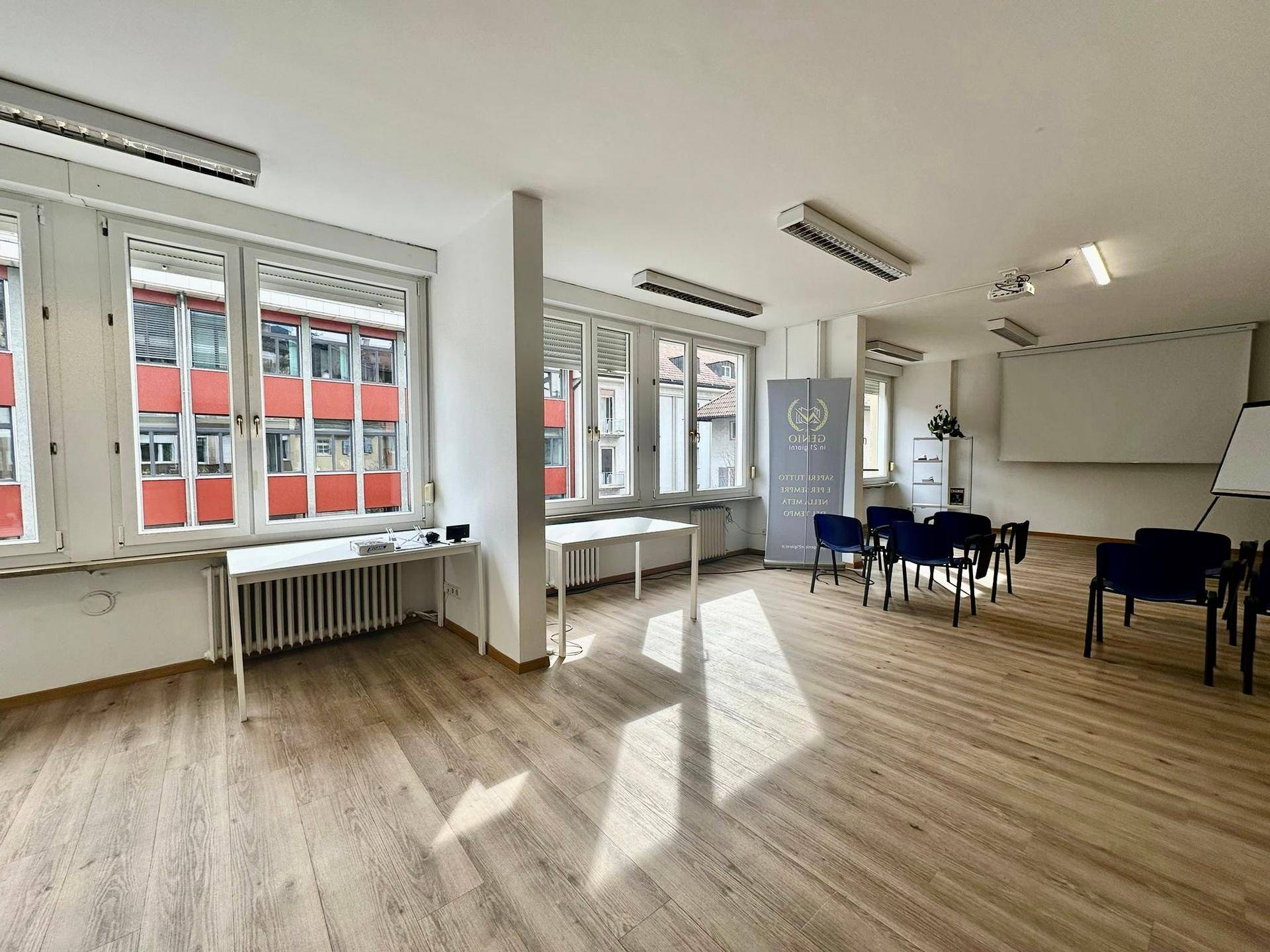 Geräumiger Bürobereich mit viel Tageslicht, Holzoptikboden und flexibler Bestuhlung für Veranstaltungen.