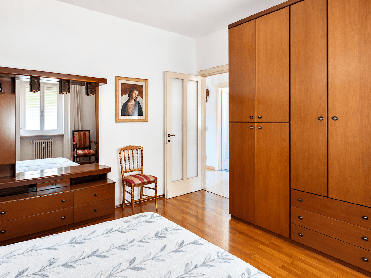 Schlafzimmer mit großem Holzschrank, Doppelbett und einem weiteren Blick auf die traditionelle Einrichtung.