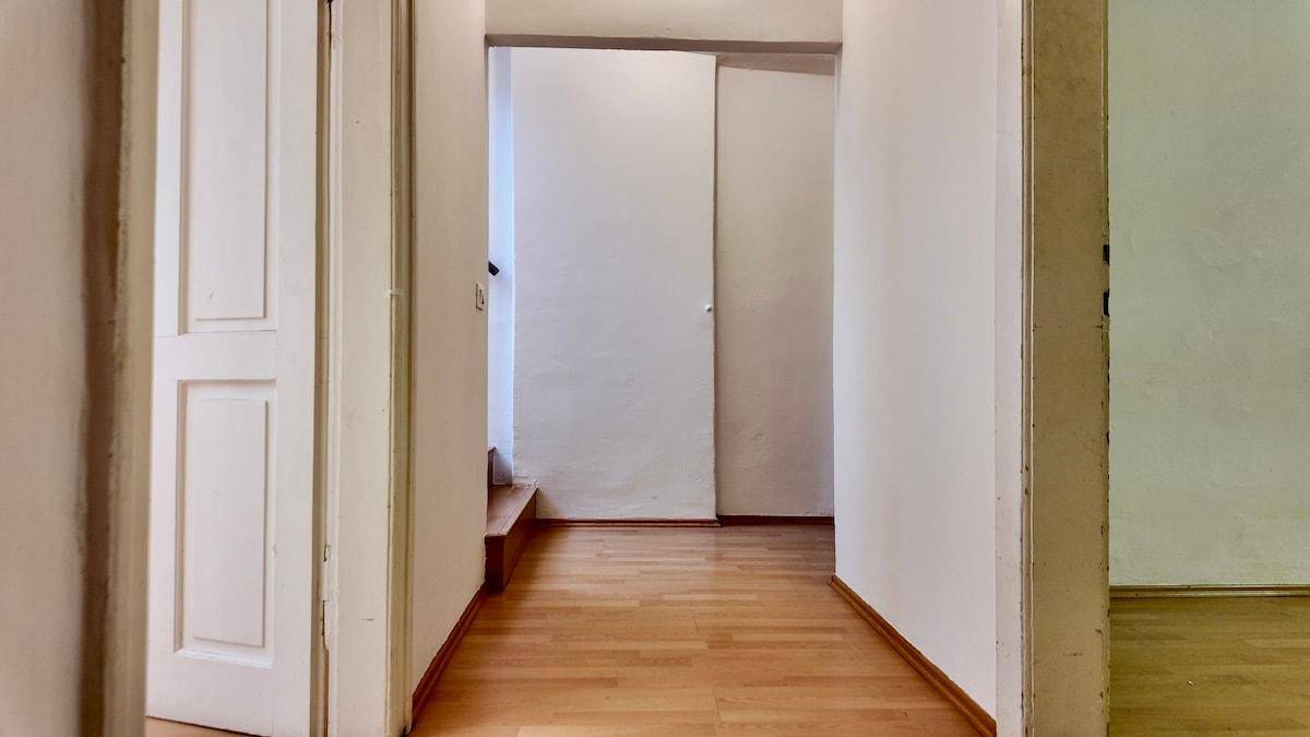 Heller Flur mit Holzfußboden und mehreren Türen, der verschiedene Räume verbindet.