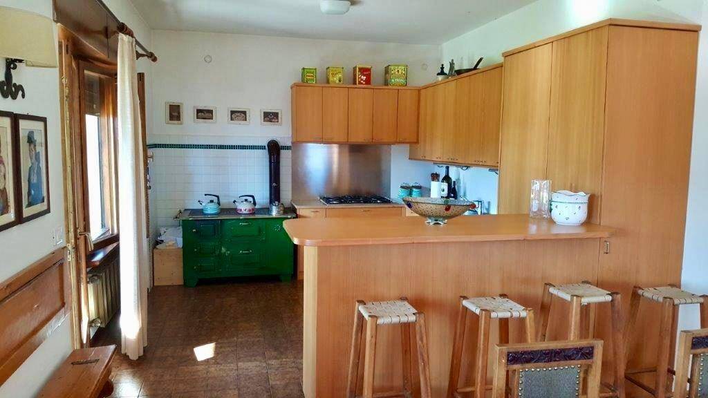 Funktionale Küche mit Holzschränken, Frühstücksbar und traditionellem Herd.