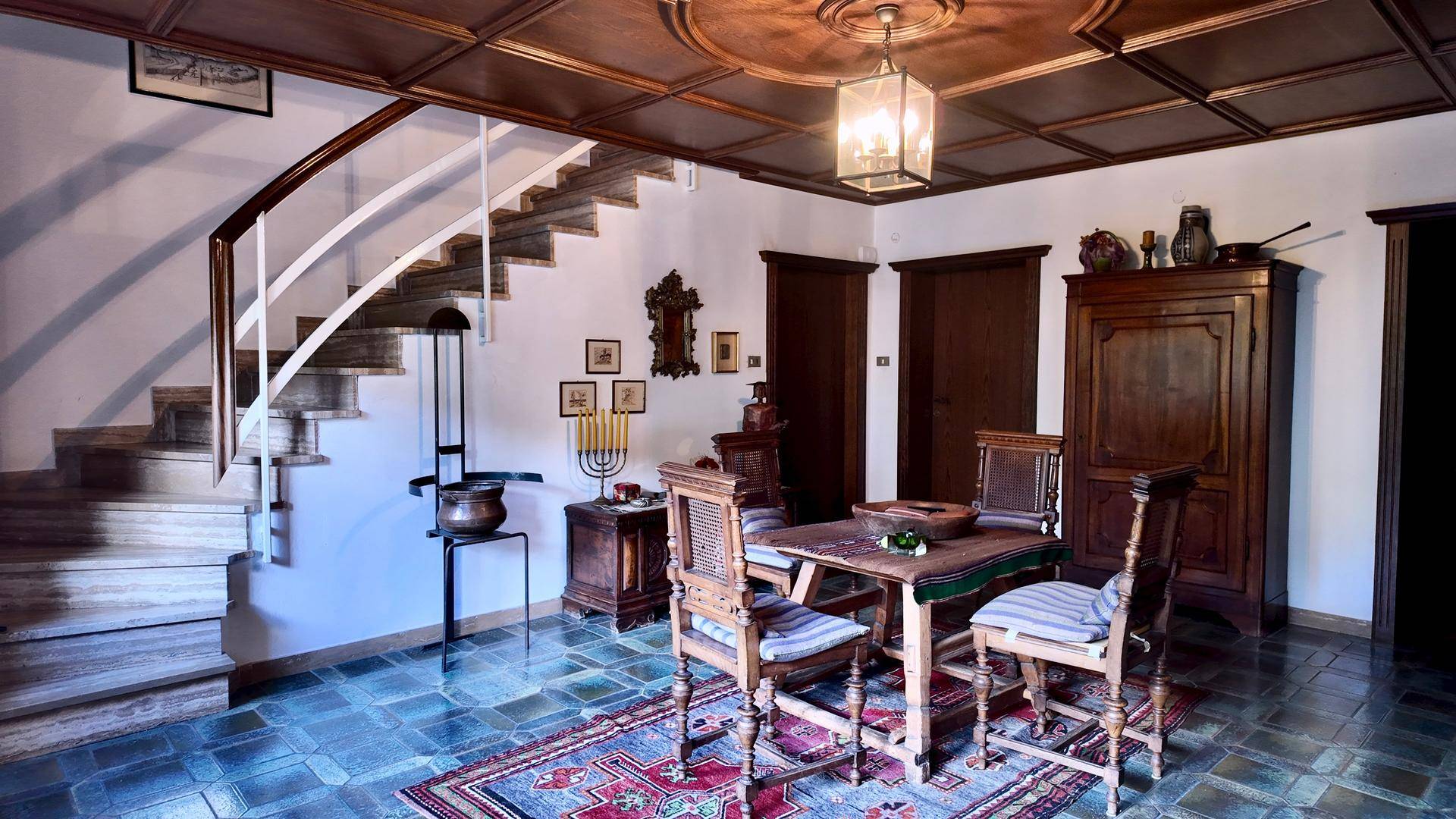 Traditioneller Eingangsbereich mit Holzdecke, gefliestem Boden und eleganter Marmortreppe.