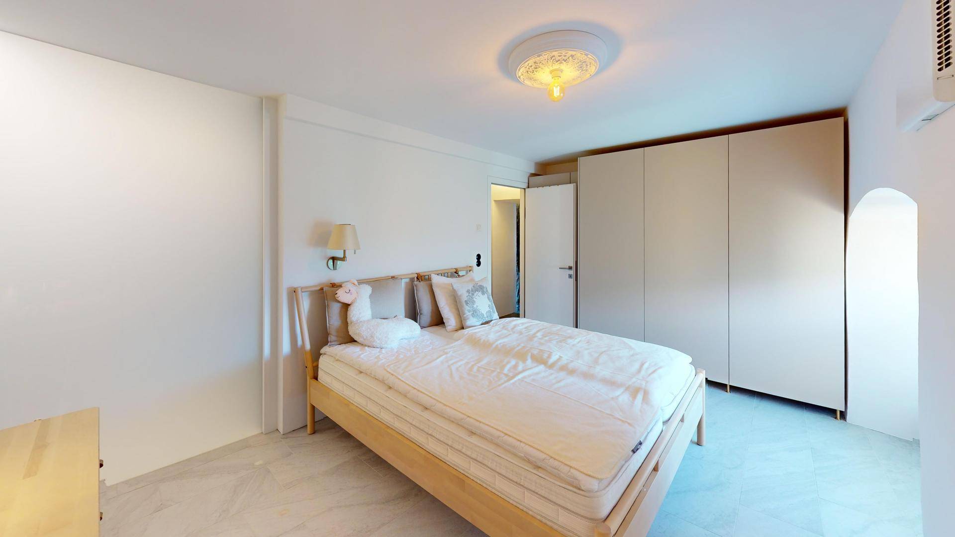 Schlafzimmer mit großem Doppelbett und praktischen Einbauschränken für Stauraum.