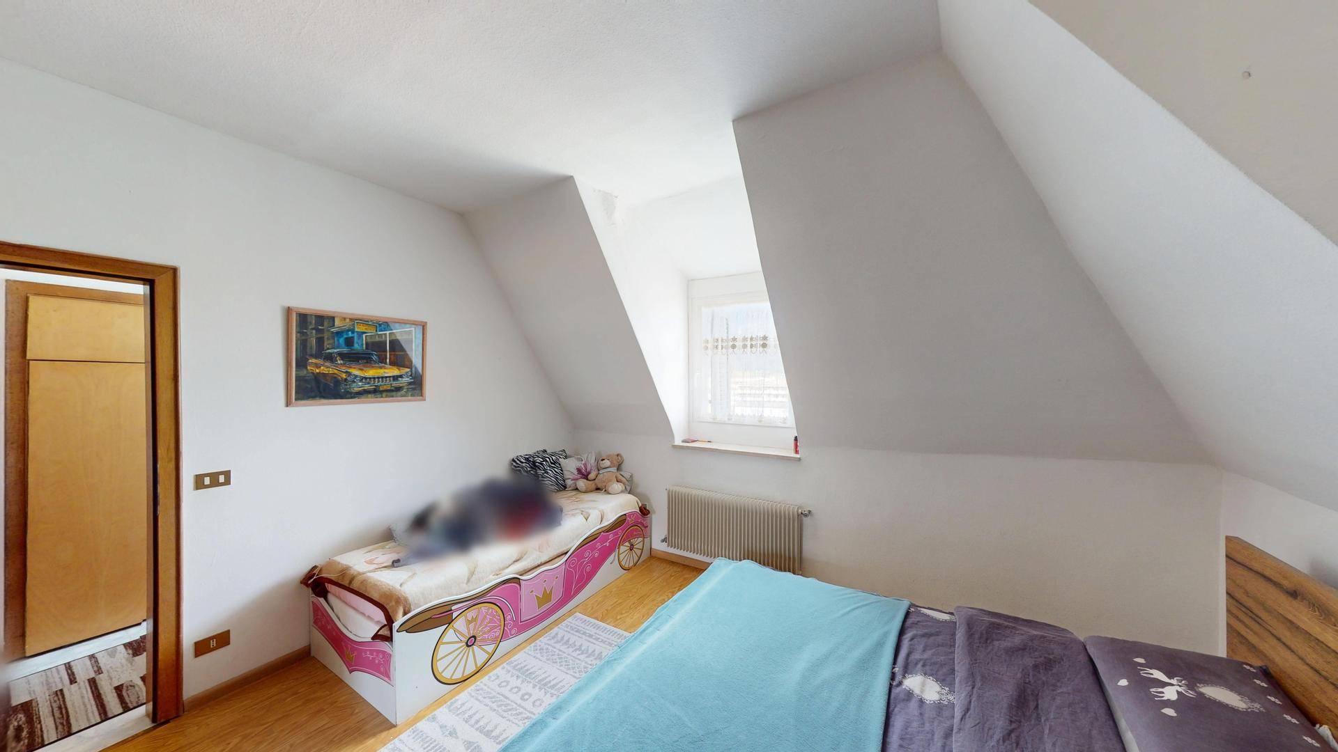 Kinderzimmer mit Dachschrägen, einem Einzelbett und einem Fenster für ausreichend Tageslicht.