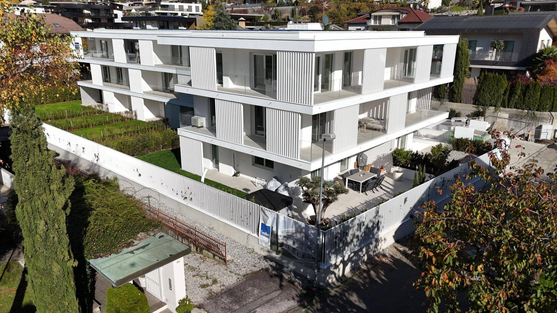 Moderne Wohnanlage mit gepflegtem Garten und Außensitzbereich.
