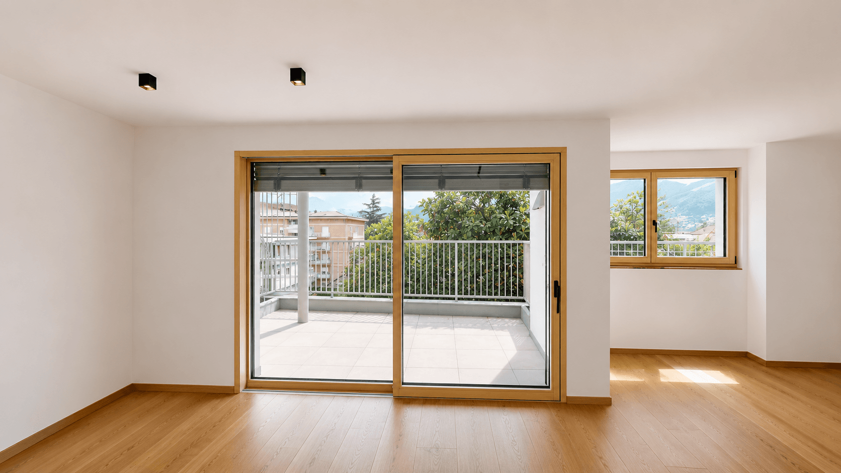Lichtdurchfluteter Raum mit Holzboden und Schiebetür zum Balkon, ideal für einen Wohnbereich.