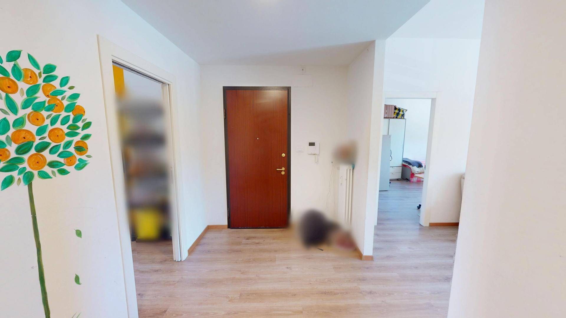 Eingangsbereich mit Holzboden und einer dekorativen Wandmalerei, Blick zum Schlafzimmer.