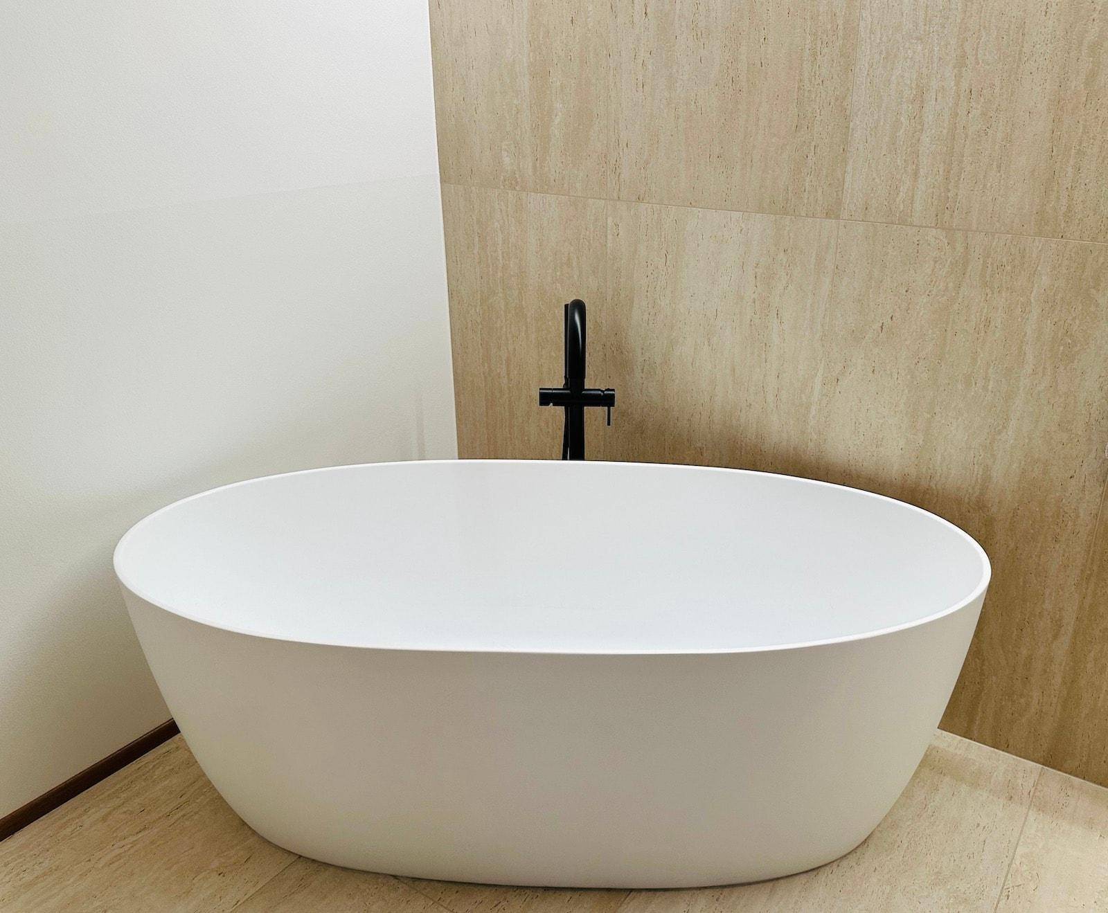 Freistehende Badewanne mit schwarzer Armatur in einem modernen Badezimmer.