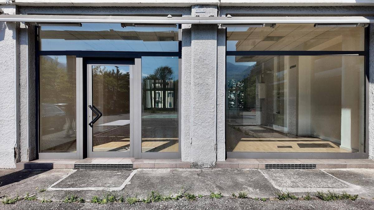 Moderne Fassade eines Geschäftsgebäudes mit großen Schaufenstern und einladender Eingangstür.