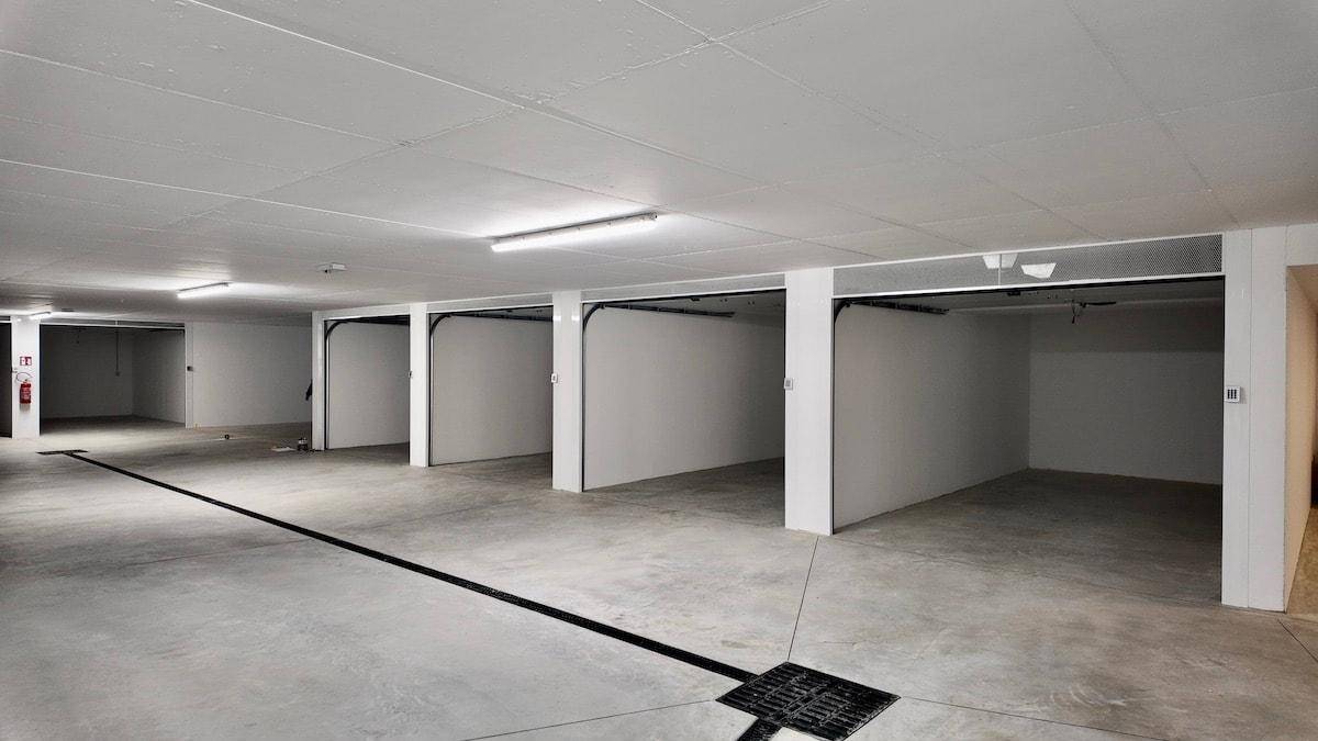 Geräumige Tiefgarage mit mehreren Stellplätzen und heller Beleuchtung.