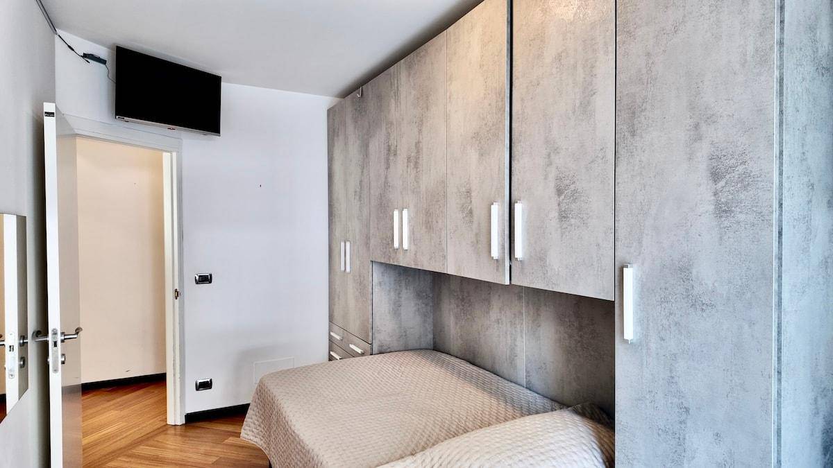 Schlafzimmer mit Einbauschränken, Fernseher und Holzboden.
