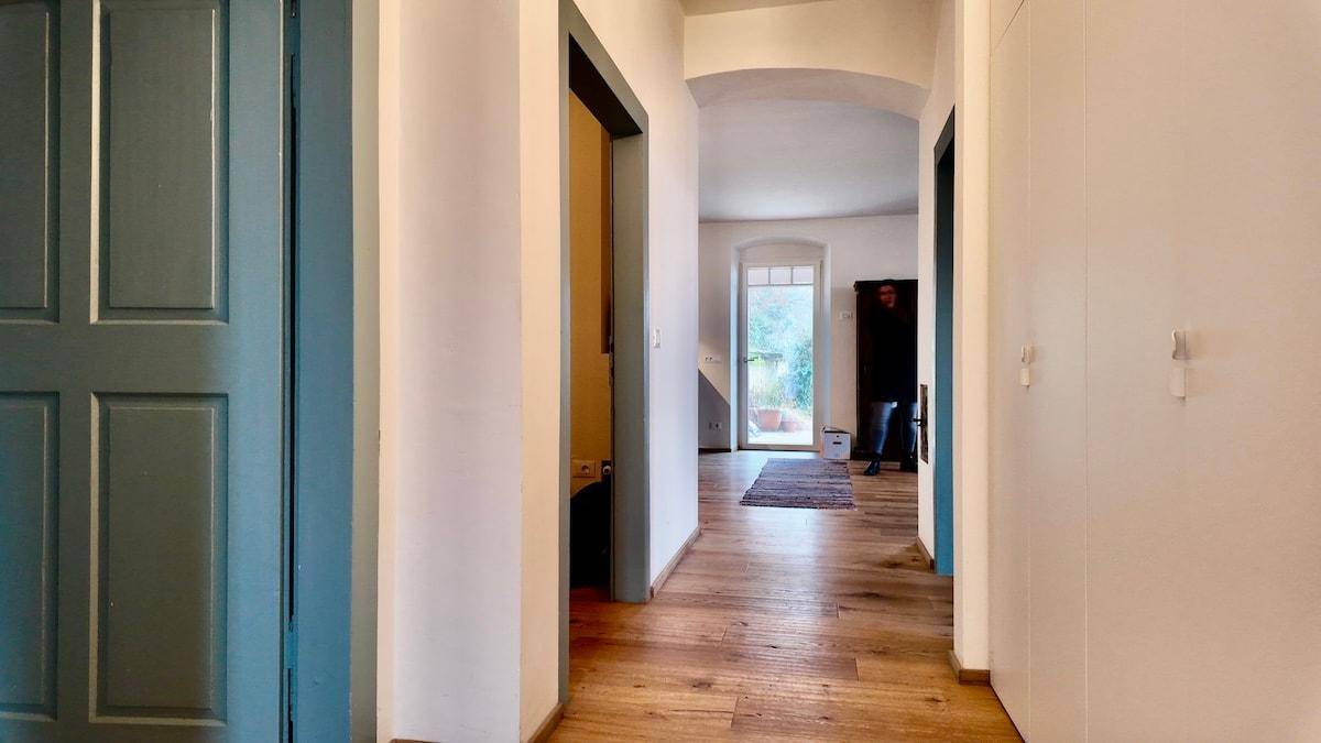 Heller Flur mit Holzboden und Zugang zu verschiedenen Räumen und dem Außenbereich.