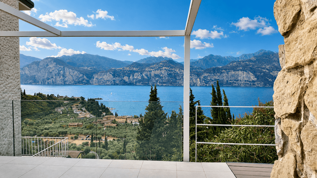 Moderne Terrasse mit Pergola und atemberaubendem Panoramablick auf den See und die umliegenden Berge.